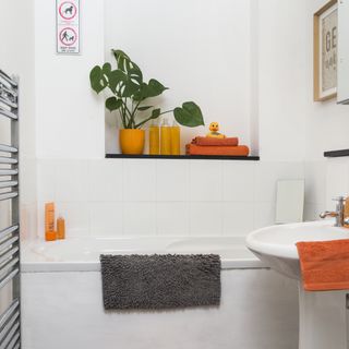 bathroom with white tiled walls and bathtub