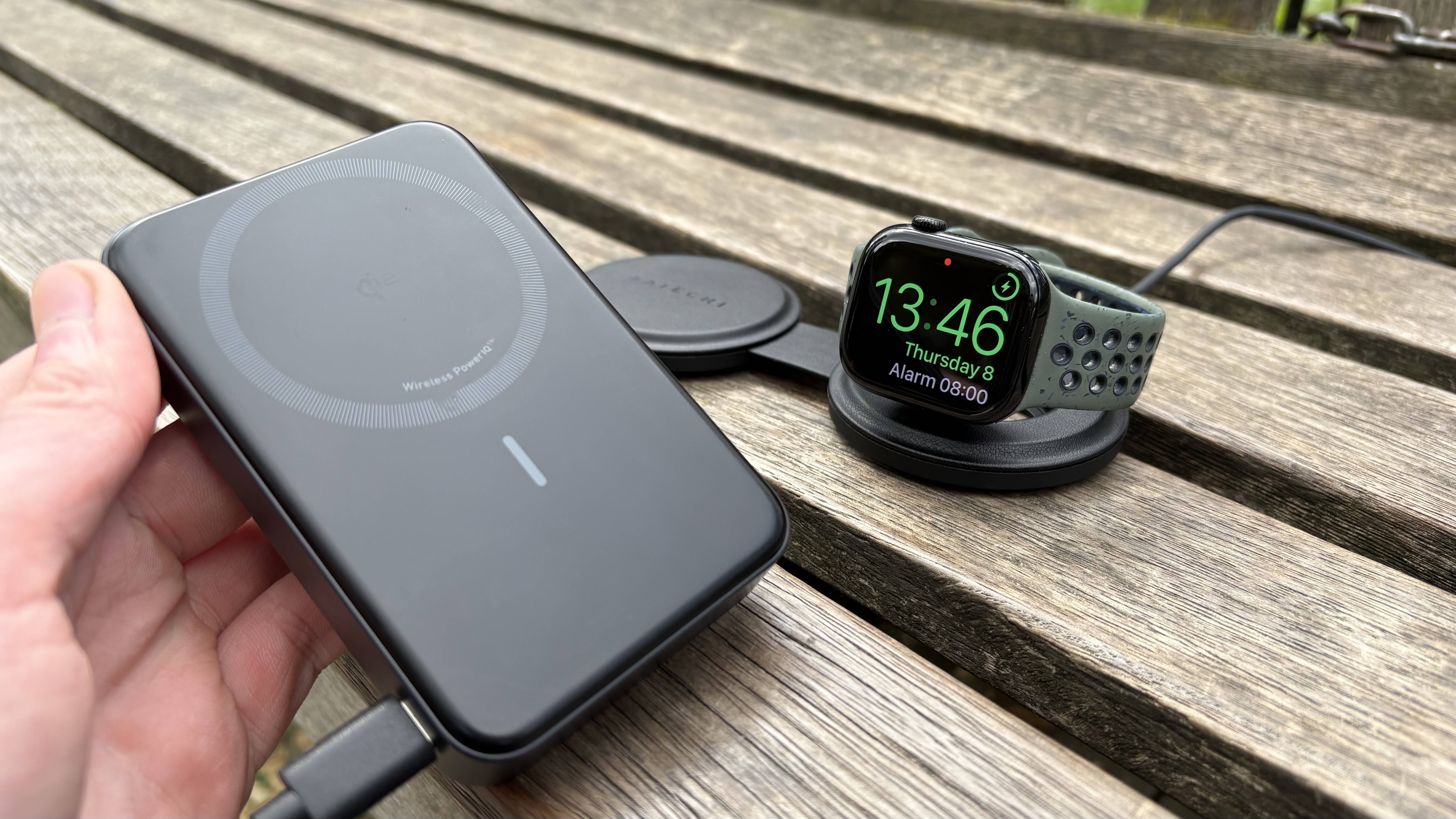 Satechi OnetheGO Charger with Apple Watch being charged on bench with Anker MagSafe power bank in hand