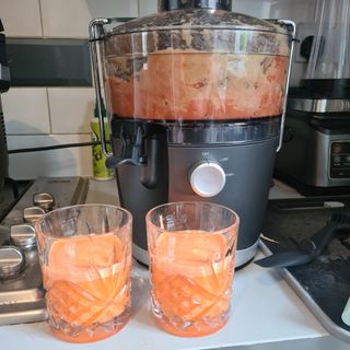 nutribullet with two glasses of carrot juice by it