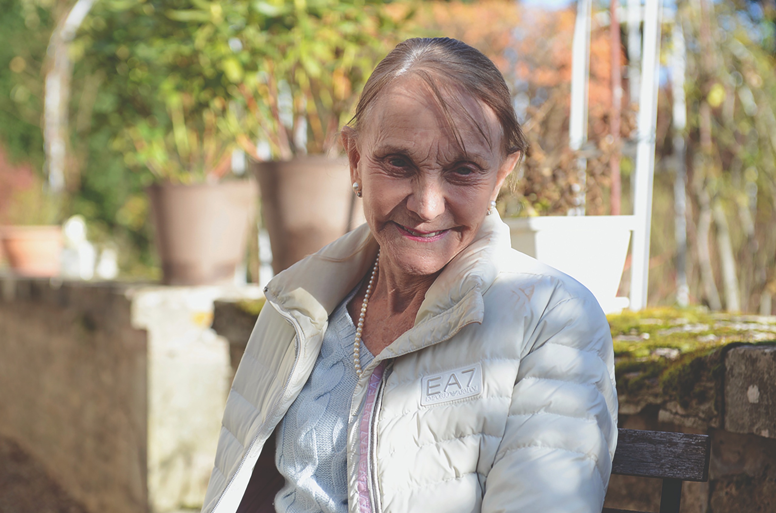 Lady sitting on a bench looking at the camera