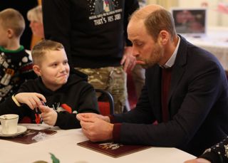 Prince William frowns while attending a Christmas party