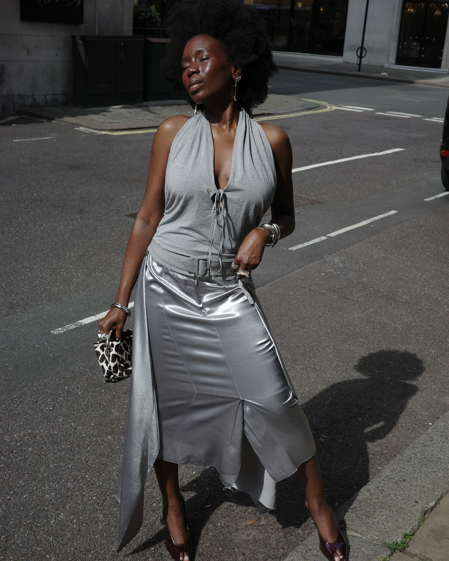Influencer @daniellejinadu wears a grey top with a grey skirt and burgundy heels.