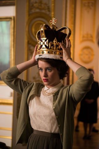 A young Queen Elizabeth tries on her crown in 'The Crown'