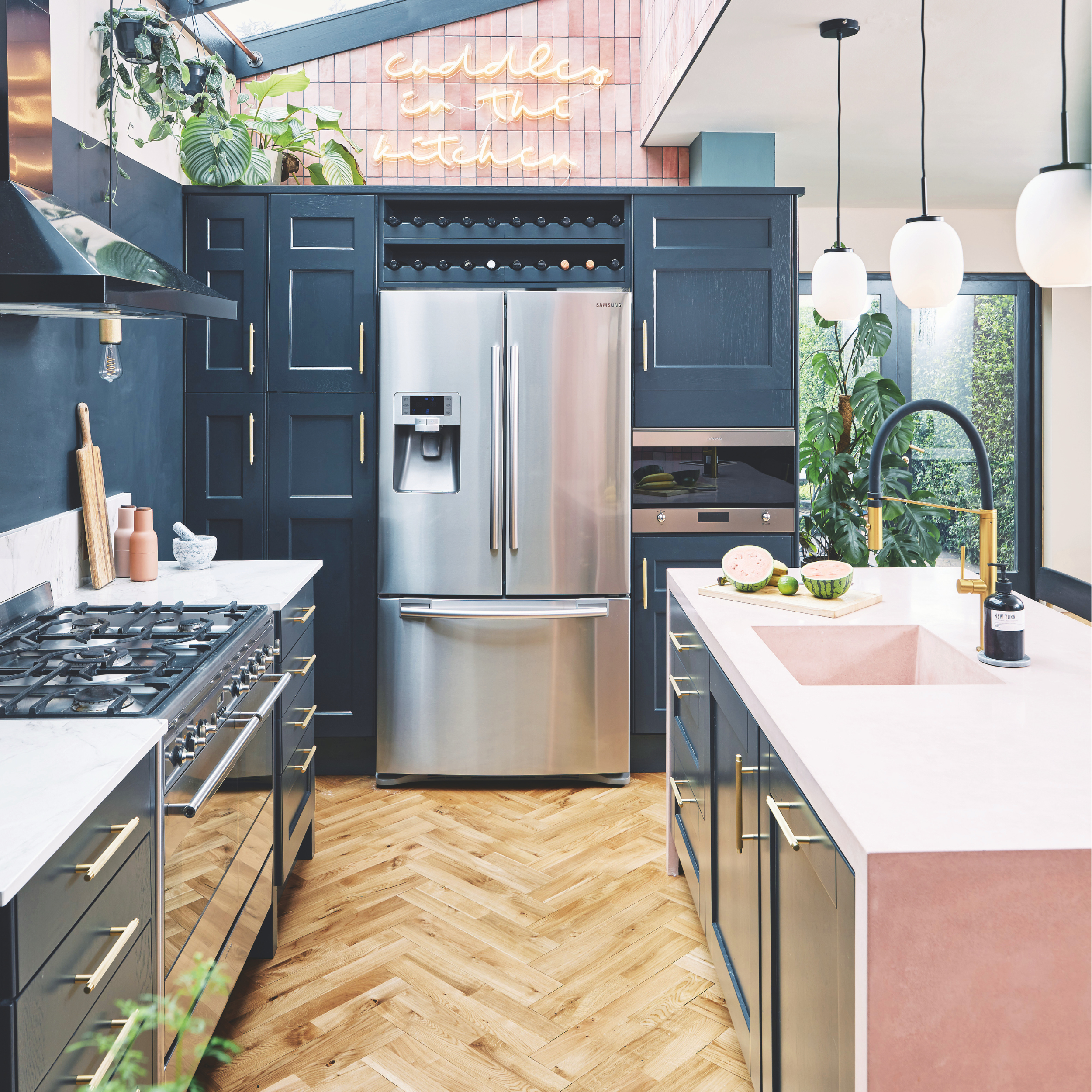 Kitchen with wooden flooring, blue cupboards and a large American-style fridge freezer in the middle