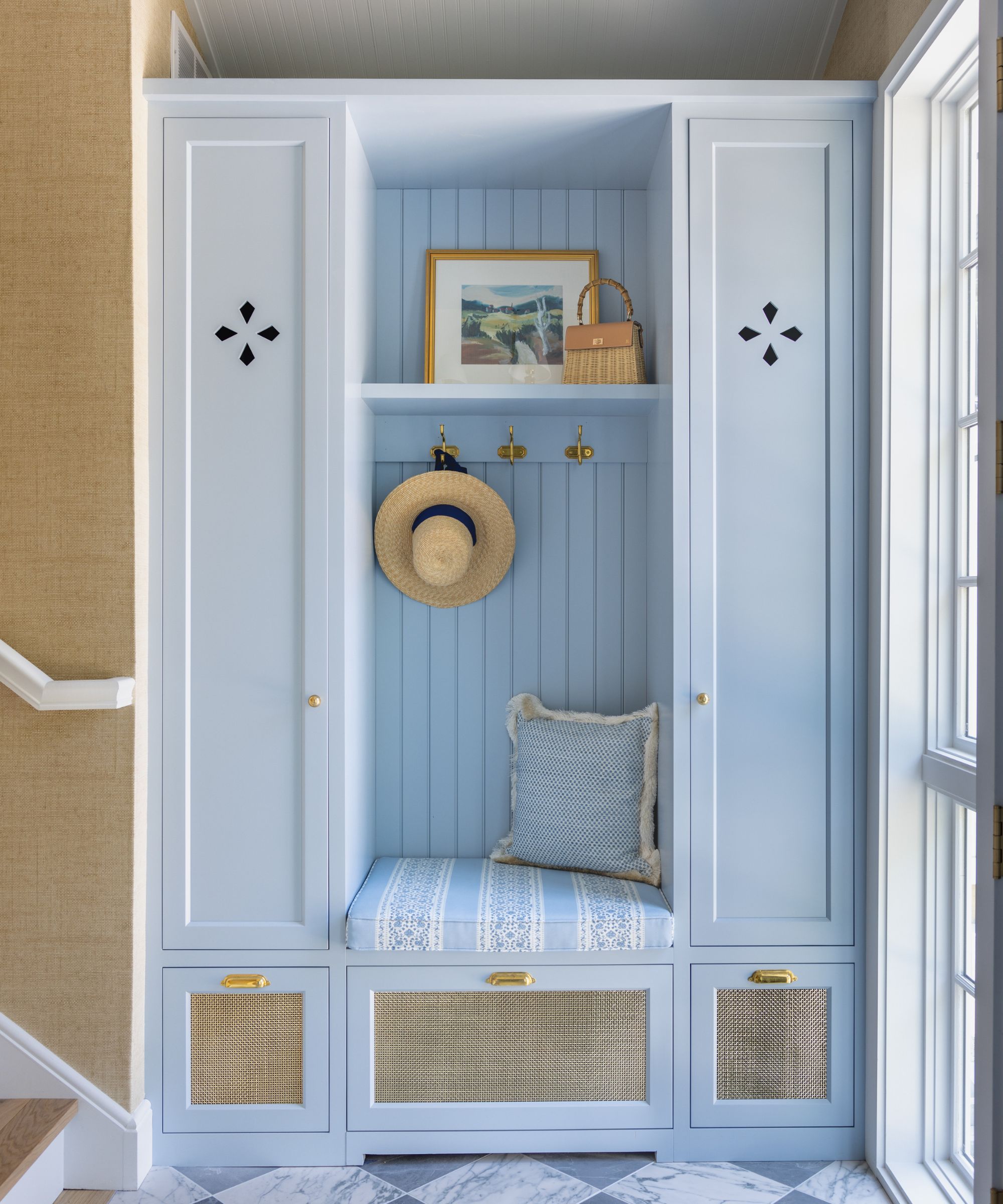 Entryway with pale blue painted built-in storage and bench and checkerboard tiles