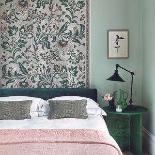 Green and pink bedroom with tapestry on wall.