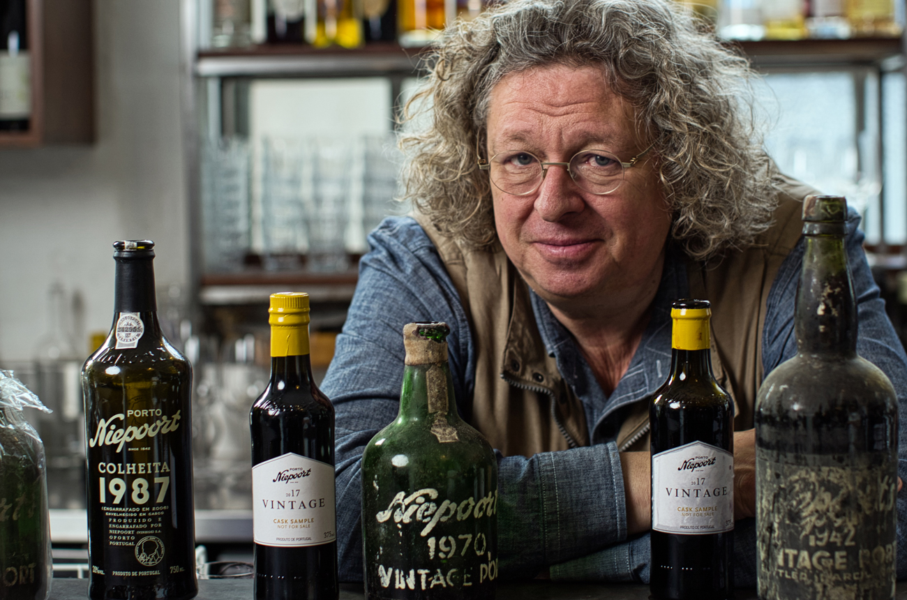 Winemaker Dirk Niepoort sitting with a selection of wine bottles
