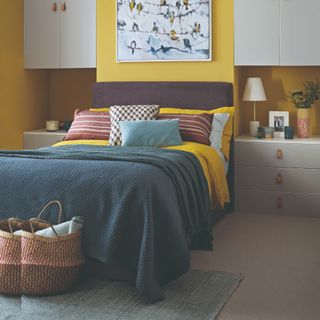 A yellow-painted bedroom with a purple headboard