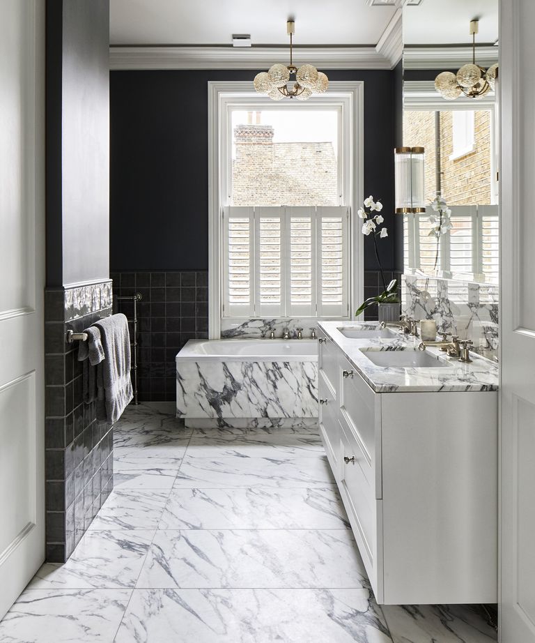 An example of bathroom pictures showing a marble bathroom with black walls and a large wall mirror