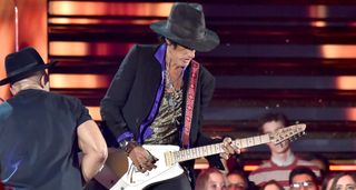 Joe Perry plays an angular retro-futuristic Kurt Hendrick electric guitar, onstage at the Grammys