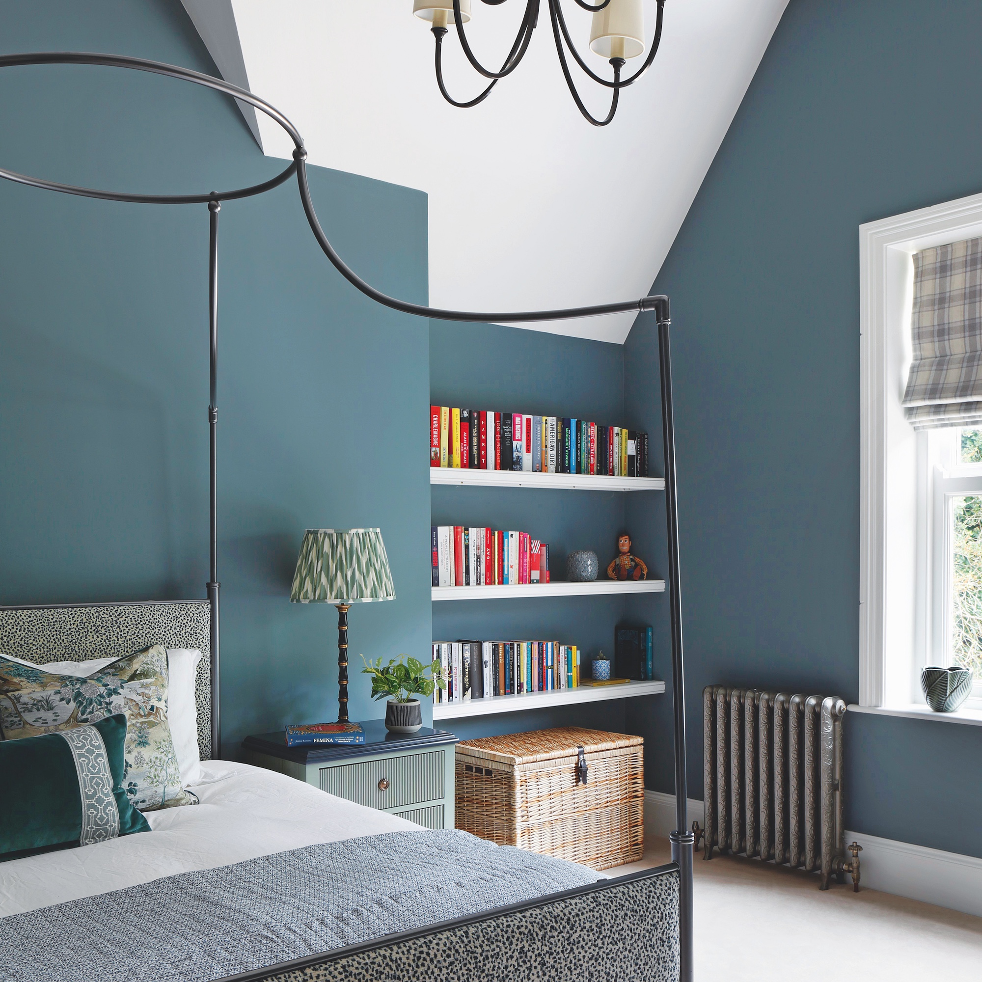 bedroom with blue painted walls and four poster metal bed