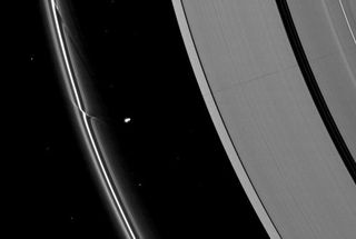 The effects of the small moon Prometheus loom large on two of Saturn's rings in this image taken a short time before Saturn's August 2009 equinox. A long, thin shadow cast by the moon stretches across the A ring on the right. The gravity of potato-shaped Prometheus (86 kilometers, or 53 miles across) periodically creates streamer-channels in the F ring, and the moon's handiwork can seen be on the left of the image. Image released Jan. 28, 2010.