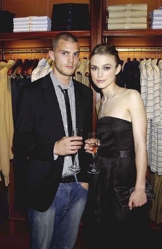Jamie Dornan and Keira Knightley holding glasses of champagne.