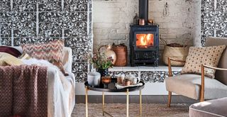 Brown living room with pattenred wallpaper and log burner to support a guide on how to keep your house warm in winter