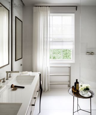 Bathroom curtain ideas with white sheer curtain and blind, layered over window in white bathroom