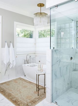 white bathroom with marble and bathroom rug with shower