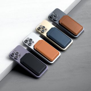 Four iPhones face down with Satechi magnetic wallet stands attached to them