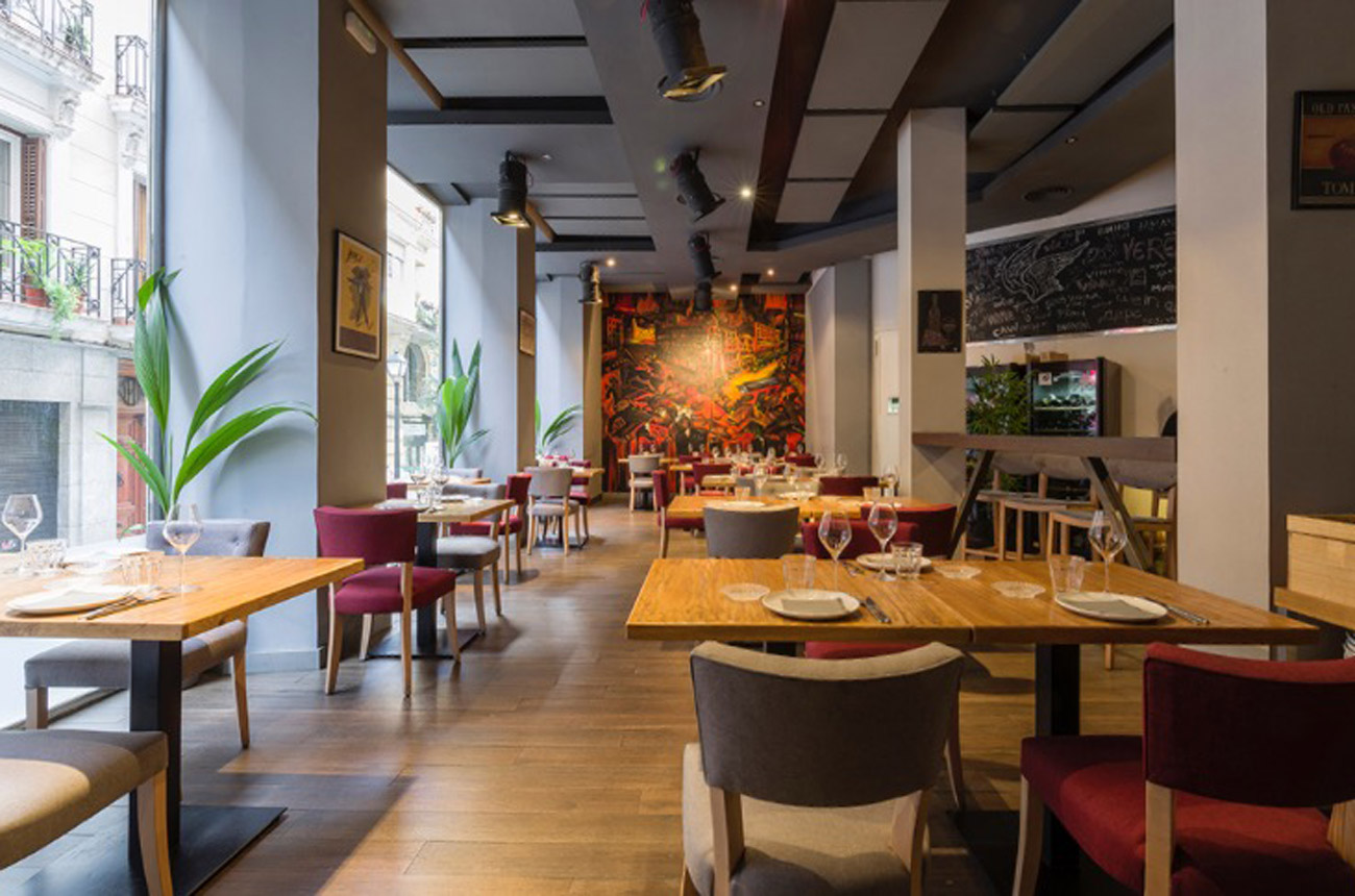 Tables and chairs inside a restaurant with plants