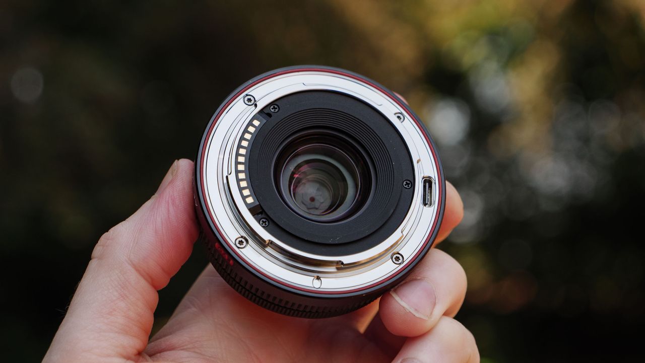 Viltrox AF 26mm F2.8 EVO 'pancake' lens in TechRadar's Cameras Editor Tim Coleman's hand, rear mount in view
