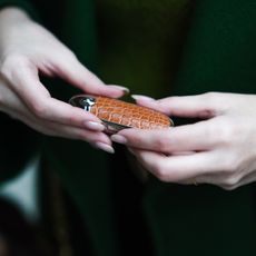 Sara Carnicella is using a Guerlain lipstick with a brown crocodile pattern case, on November 11, 2020 in Paris, France