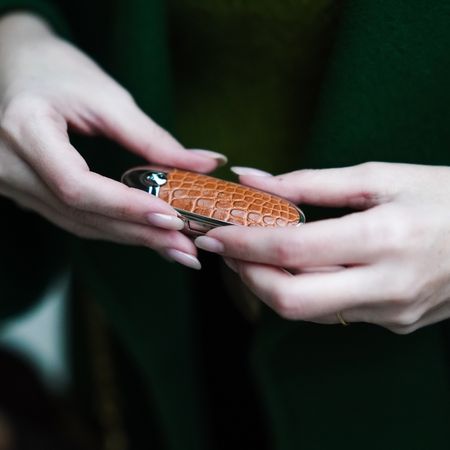 Sara Carnicella is using a Guerlain lipstick with a brown crocodile pattern case, on November 11, 2020 in Paris, France