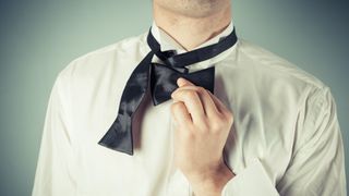 How to tie a bowtie - fold shorter half and hold horizontally