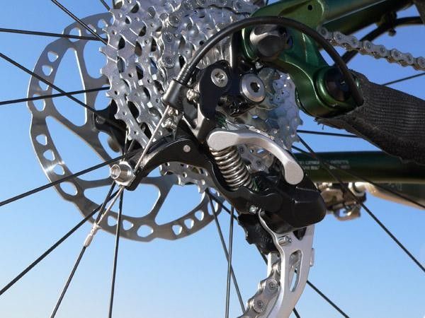 The rear derailleur cable fixes to a leverage arm on the Shadow design instead of on one of the parallelogram plates as on the conventional variants.