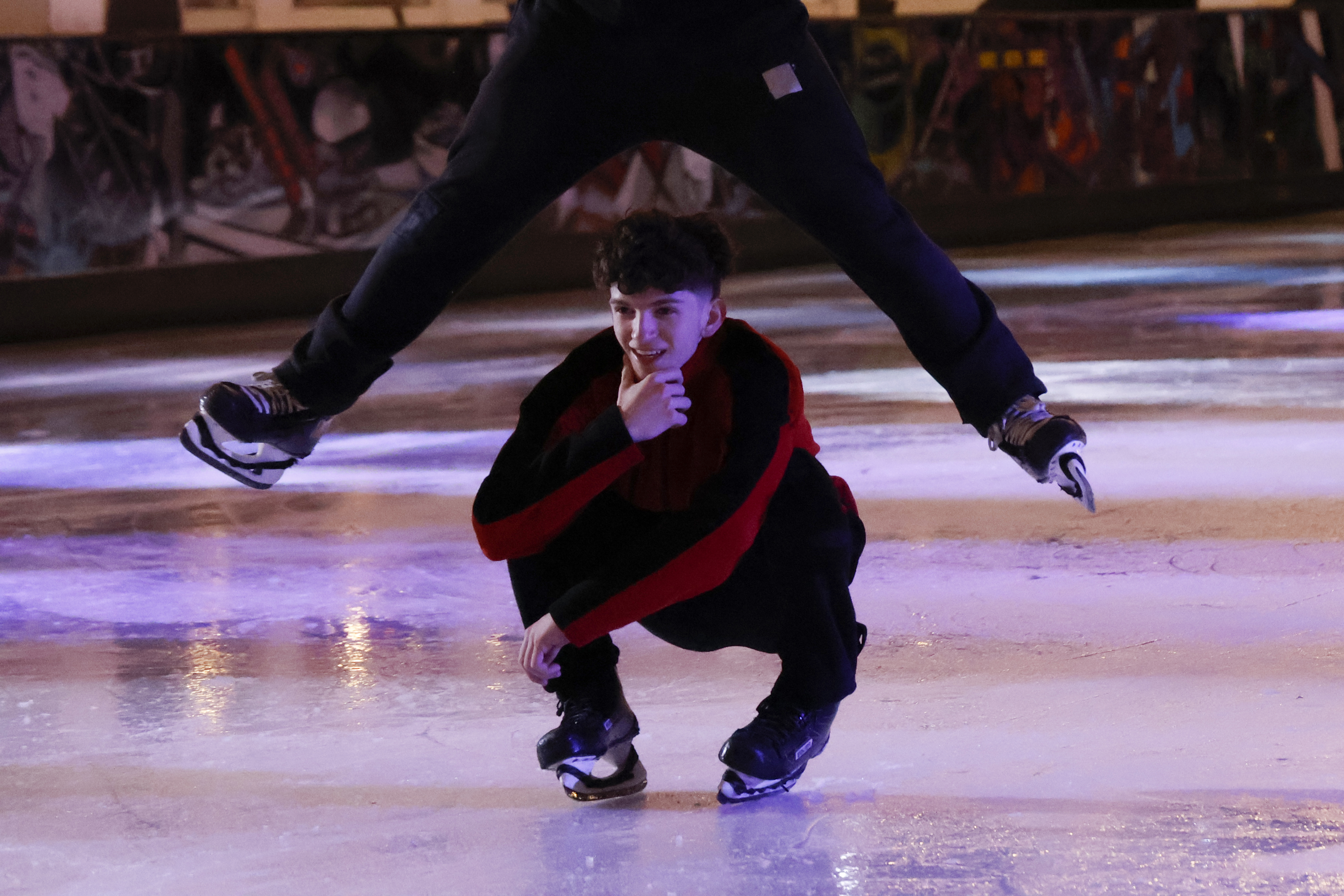 Two ice skaters performing at an ice rink