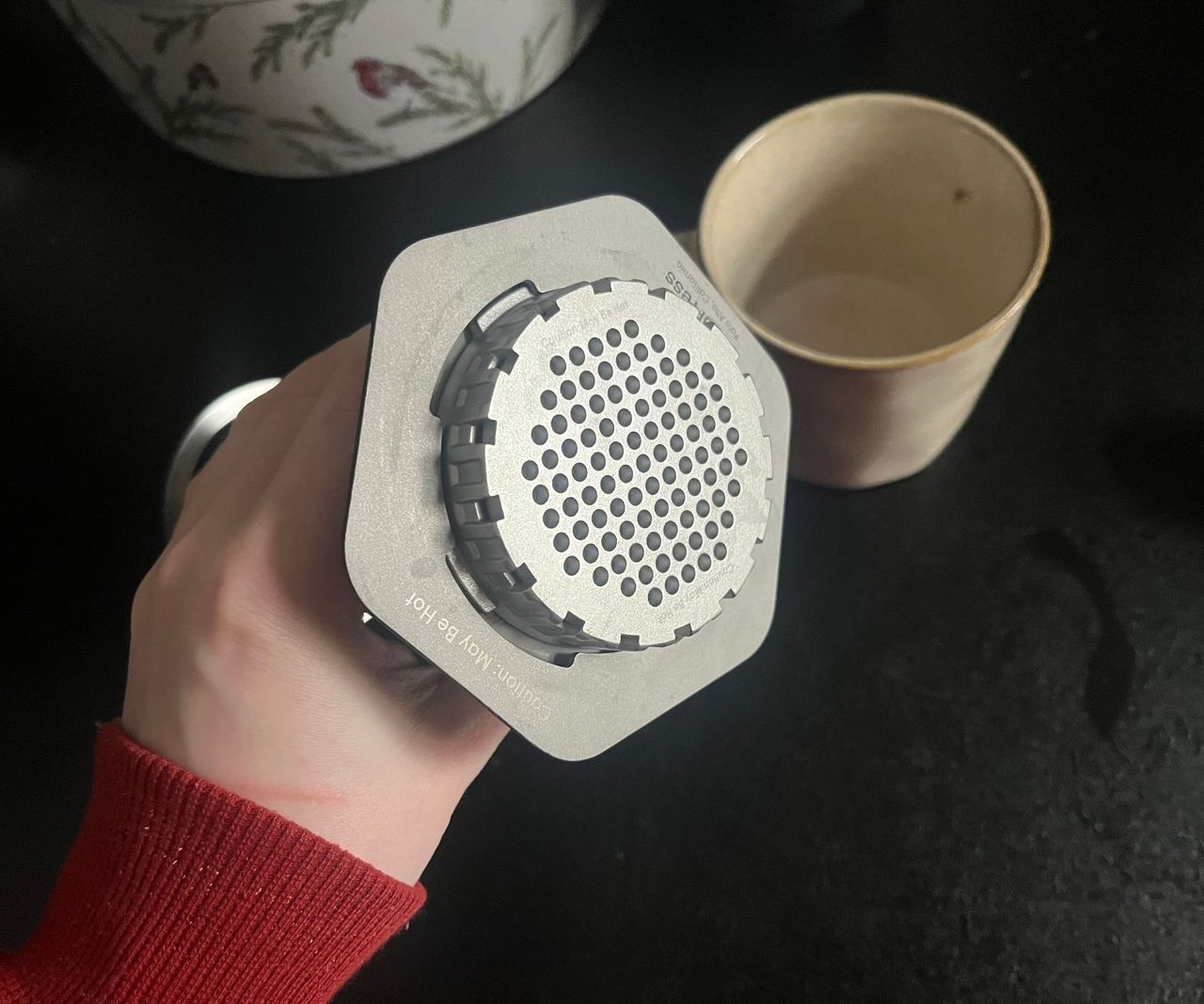 The bottom of a stainless steel AeroPress with the filter cap screwed into place.