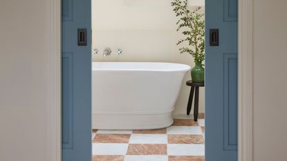  en-suite ideas bathroom behind pocket doors with white bath and red and white checkerboard tiles