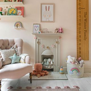 Pastel nursery with fireplace, bunting, painted floorboards and armchair