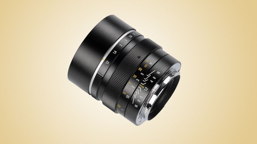 The 7Artisans MF 50mm f/1.2 on a gold gradient background