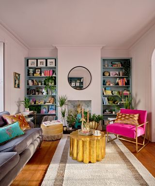 A living room with two bookshelves, a gray couch, a pink seat, and a yellow coffee table