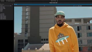 Man dancing on rooftop in hoodie with flying saucer logo on the front