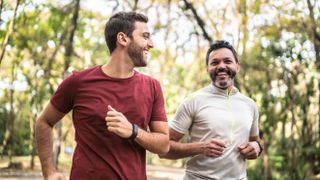 Two men running outdoors wearing fitness trackers