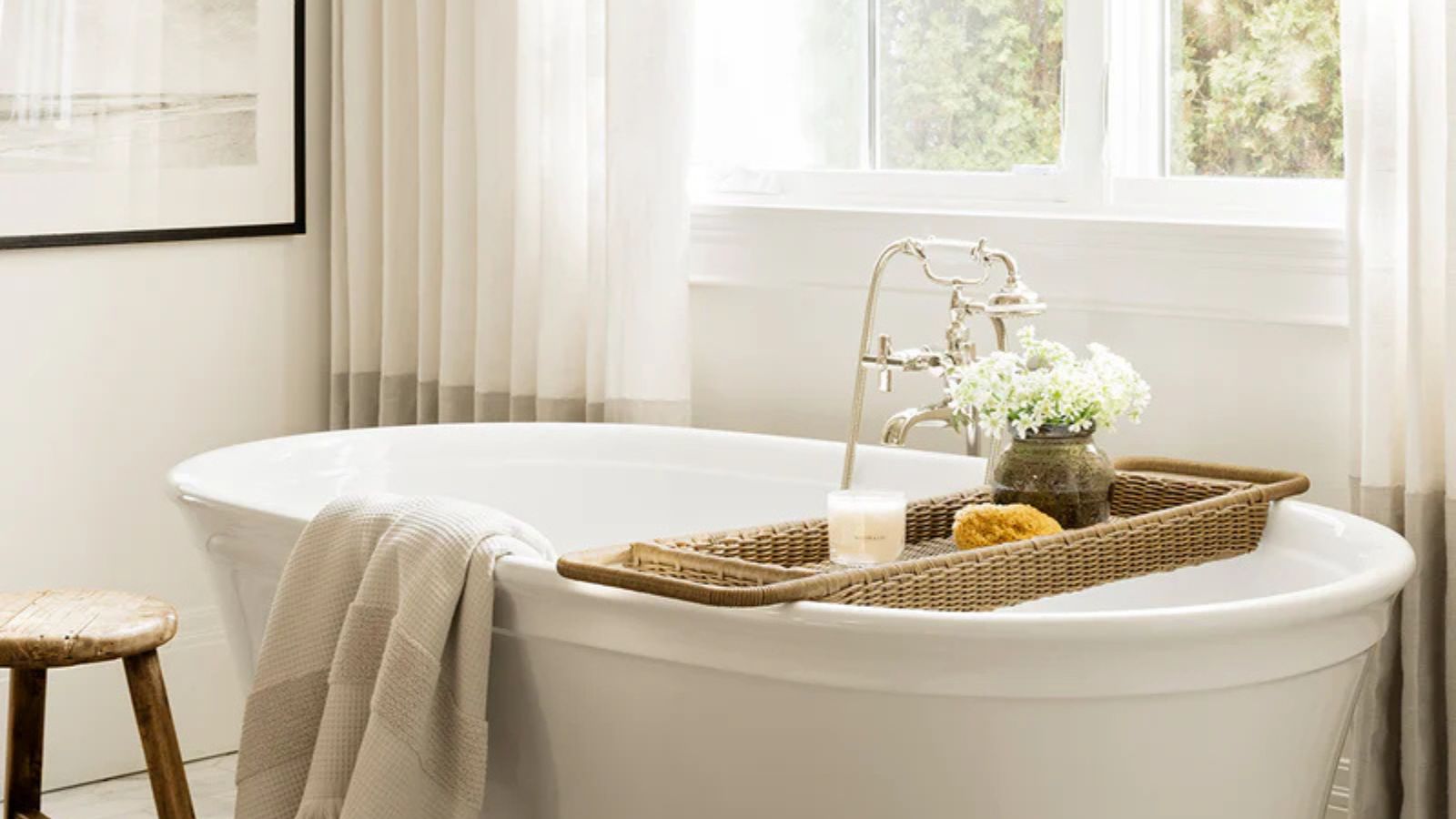 A white freestanding bath tub styles with a rattan bath caddy