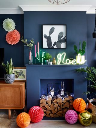 A modern fireplace with blue paint decor and neon light Christmas decorations