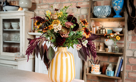 Autumn flowers in yellow striped vase