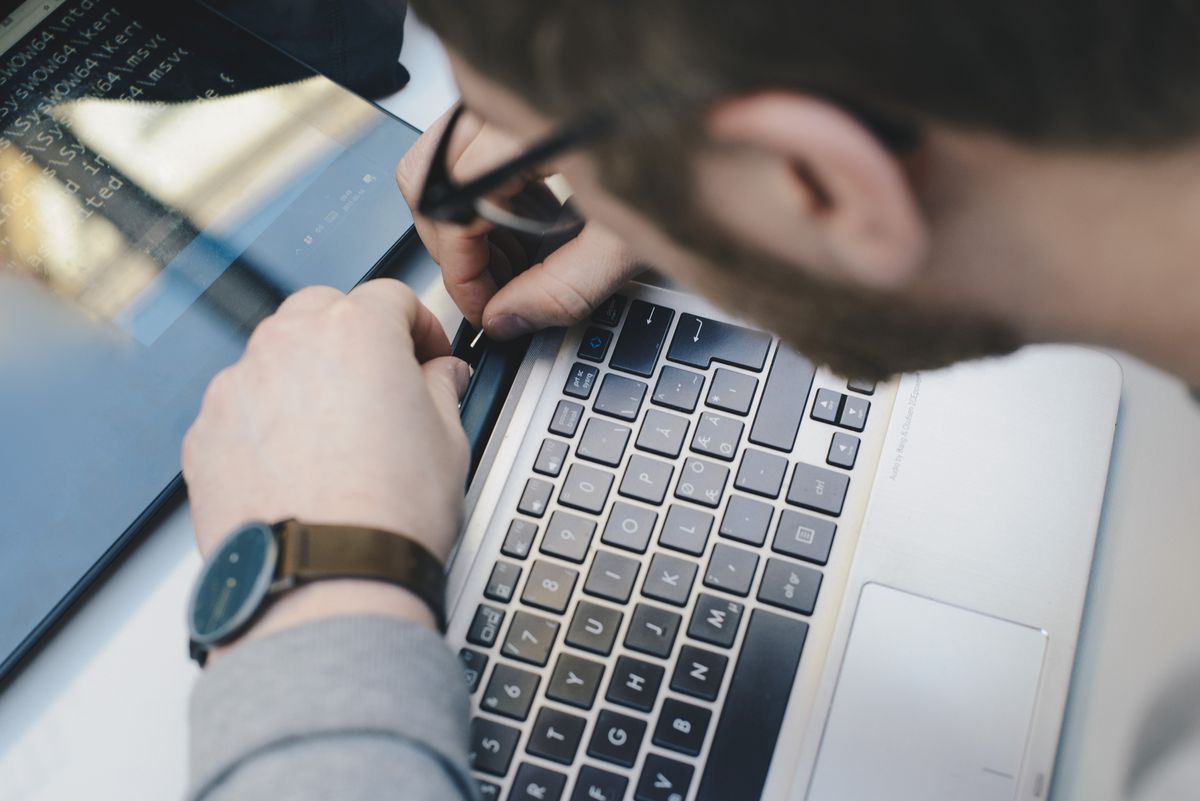 Man repairing the hinge on a laptop