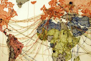 A world map coloured with string, with trails of string joining different locations