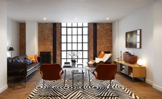 Open plan living room with floor to ceiling windows and zebra rug