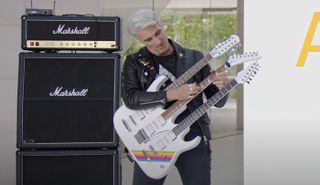Craig Federighi taps on the middle neck of a triple-neck guitar at the 2023 Apple WWDC 