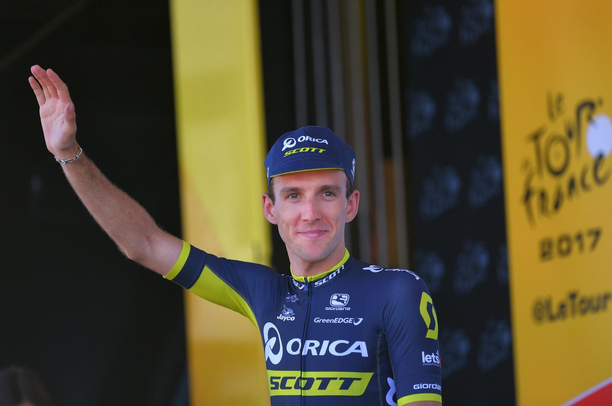 Simon Yates (Orica-Scott) waves from the podium
