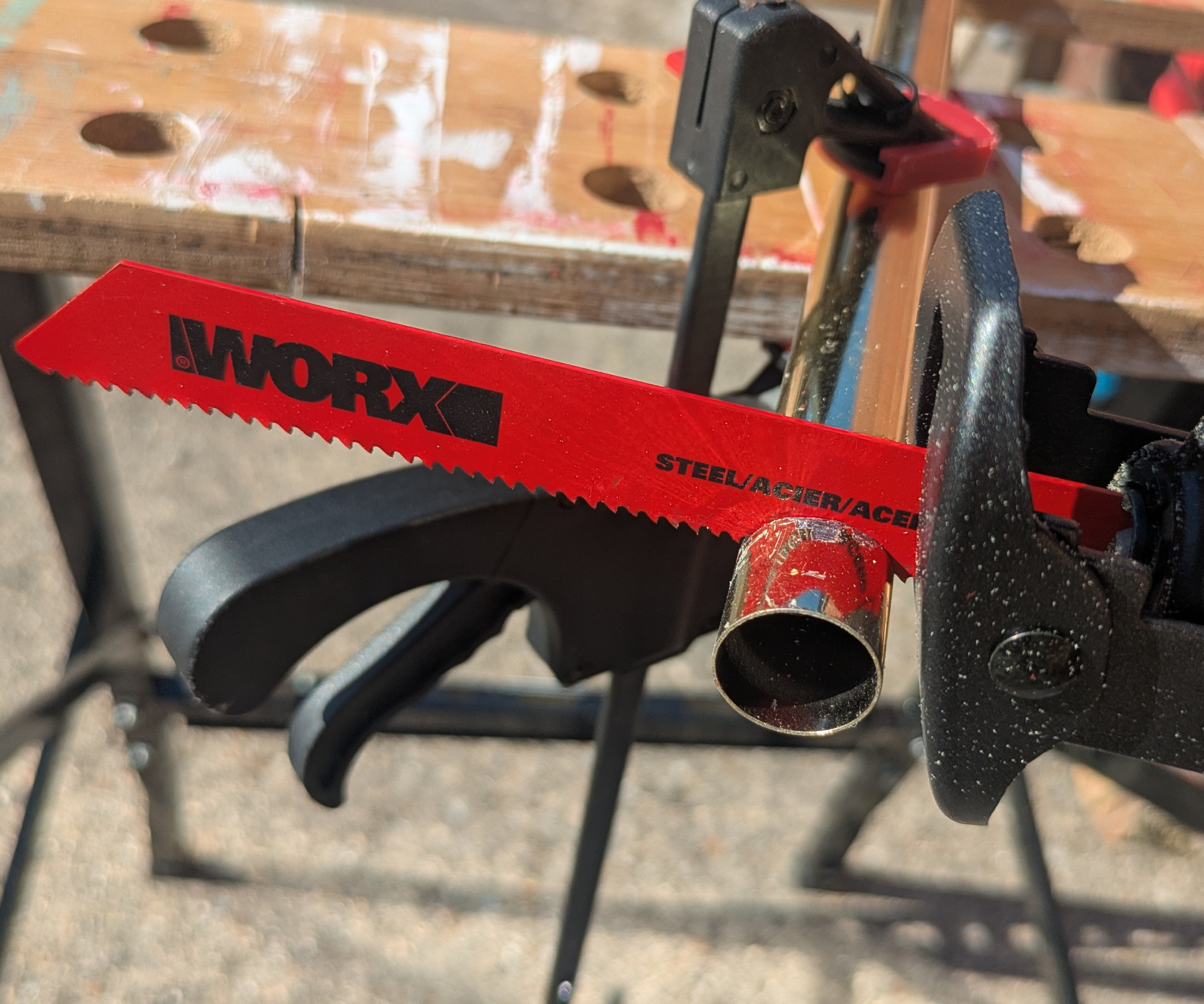 Reciprocating saw blade cutting through metal tubing