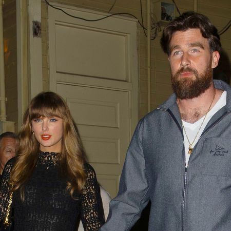 Taylor Swift wears a black lace dress with black laced boots and holds hands with boyfriend Travis Kelce ahead of the 2025 Super Bowl in New Orleans