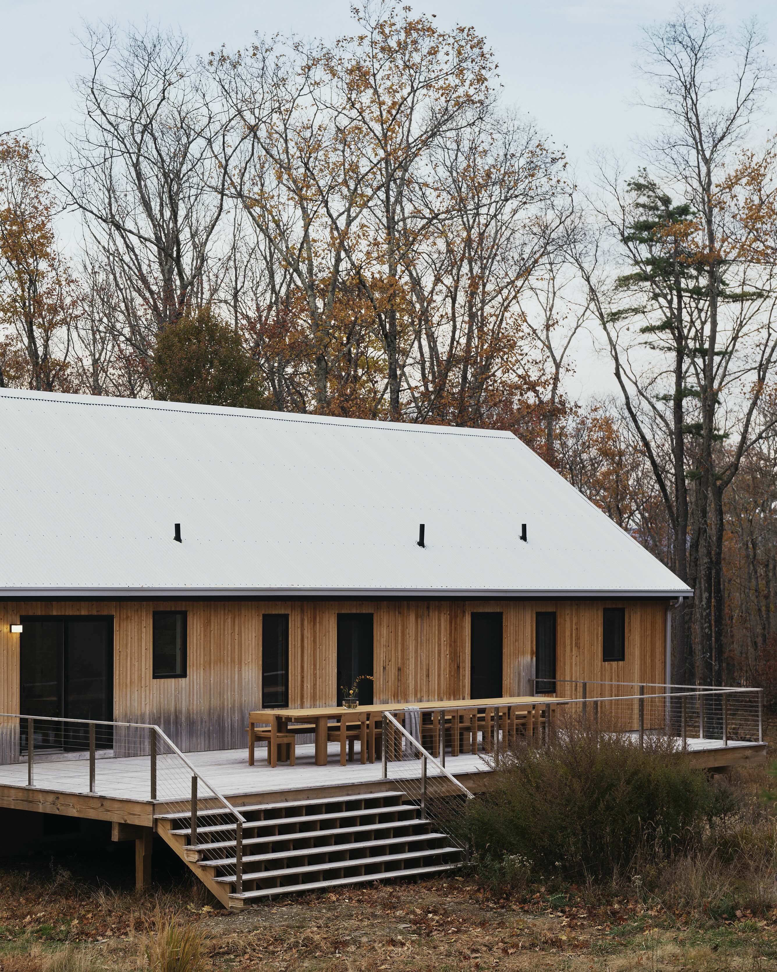 A new home with wood siding and a large deck, part of the Piaule retreat in the Catskills.