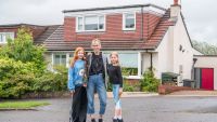 A 1960s bungalow extension in Milngavie with a mother and two children standing in front of it