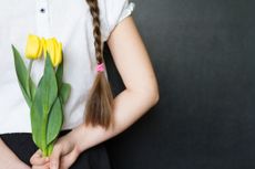 Girl with flowers against a blackboard