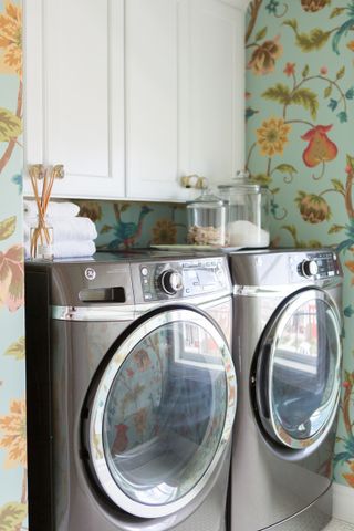 laundry room with floral wallpaper, washer and dryer