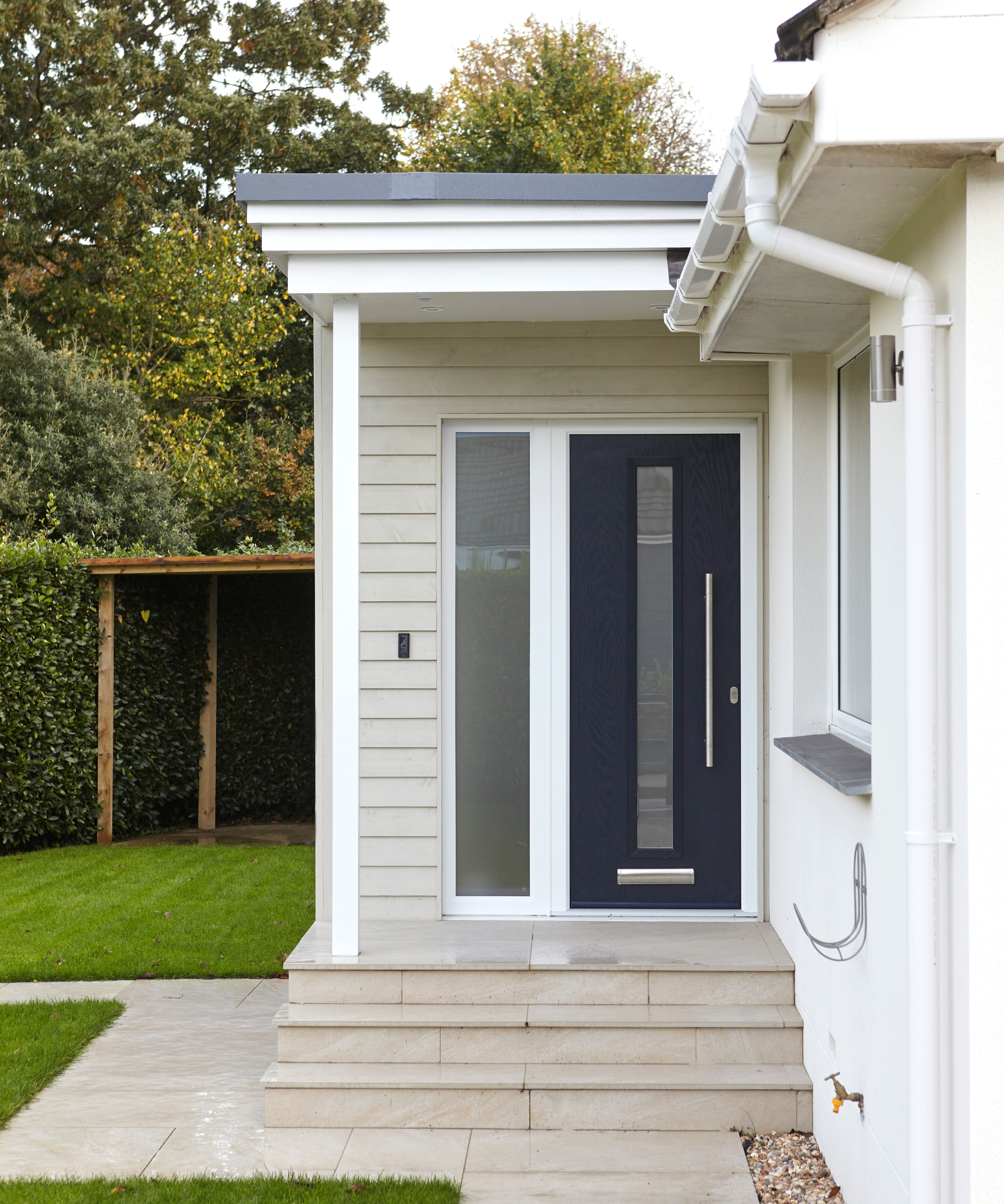 exterior of home with grey composite door on porch and cream cladding